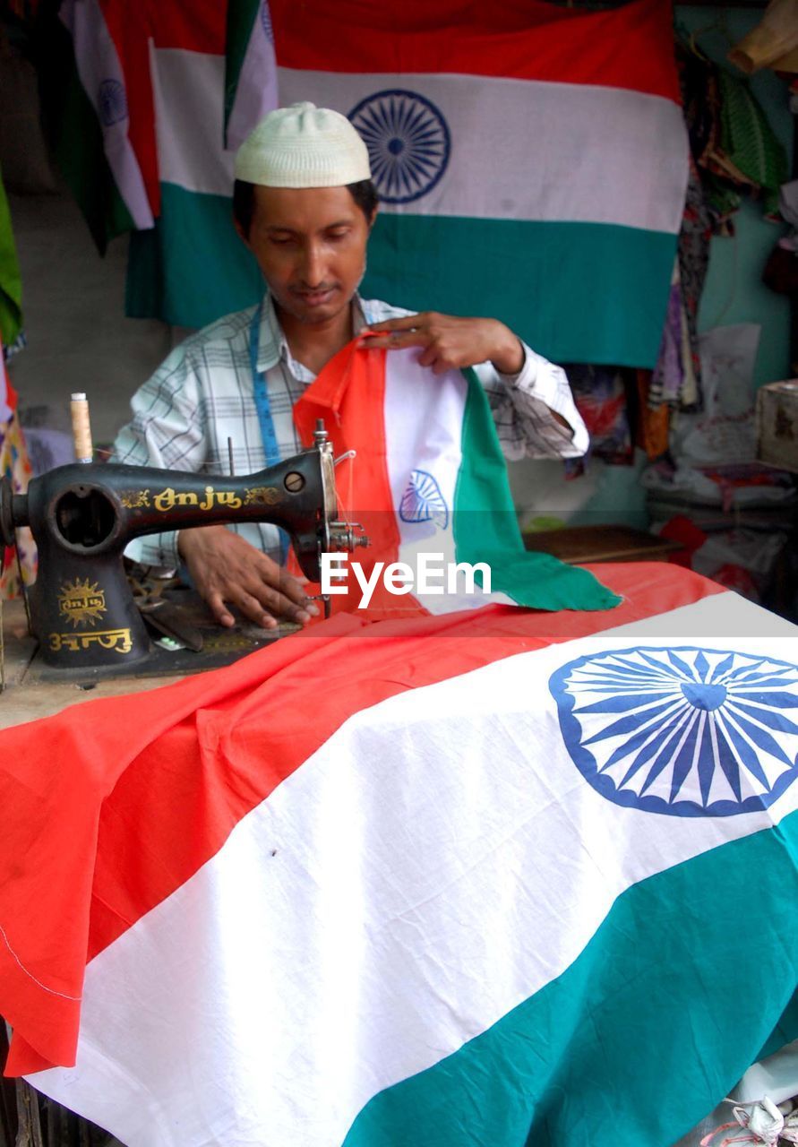 PORTRAIT OF A YOUNG MAN WORKING AT TRADITIONAL CLOTHING