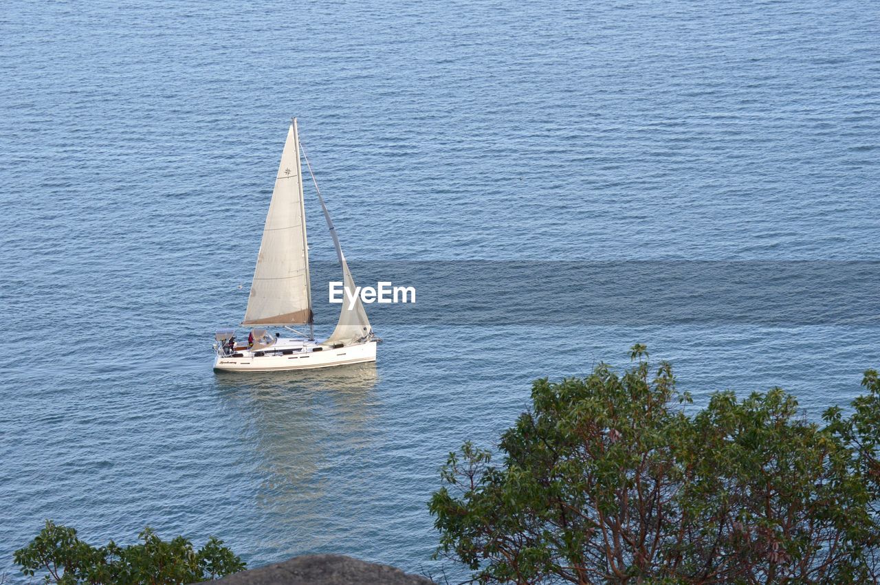 HIGH ANGLE VIEW OF SAILBOAT ON SEA