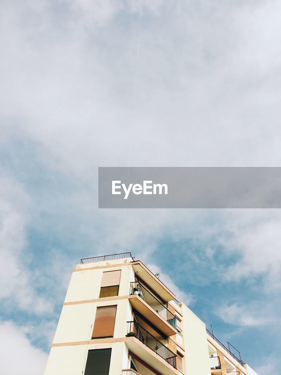 LOW ANGLE VIEW OF BUILDINGS AGAINST CLOUDY SKY