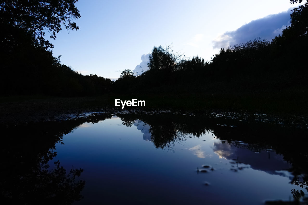 SCENIC VIEW OF LAKE AGAINST SKY AT SUNSET