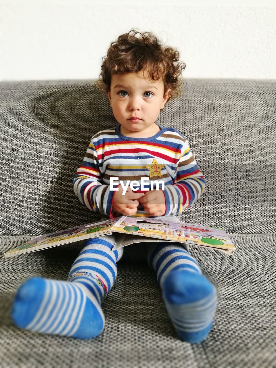 Portrait of cute boy sitting on sofa