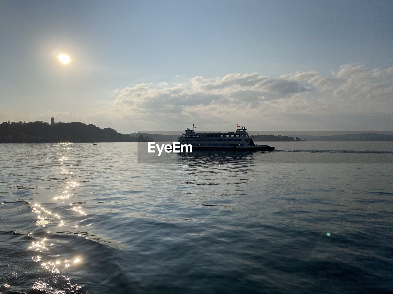 BOAT SAILING IN SEA AGAINST SKY