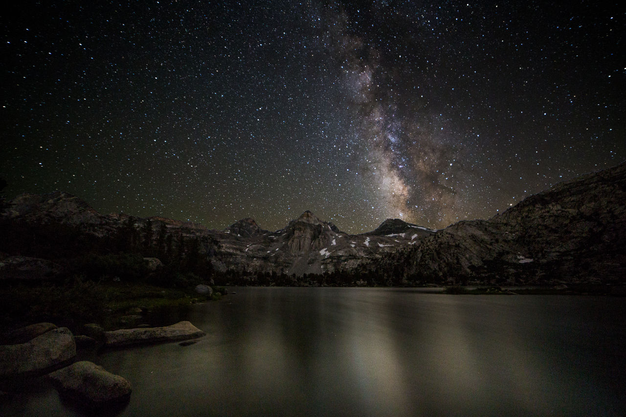 SCENIC VIEW OF LAKE AGAINST MOUNTAINS AT NIGHT