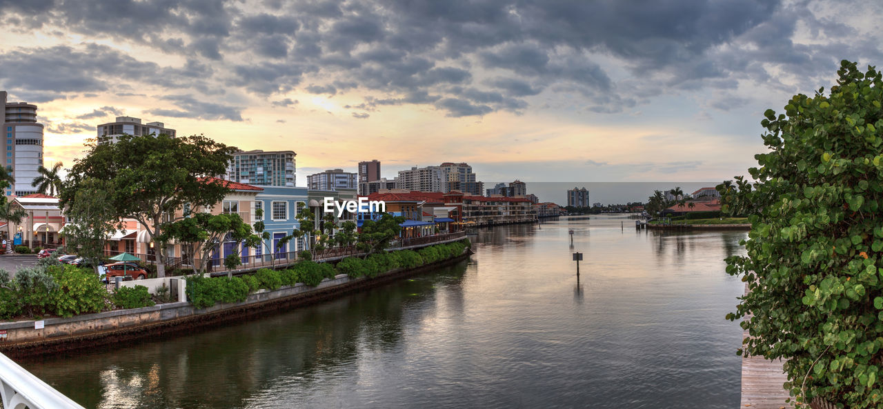 River amidst buildings in city against sky