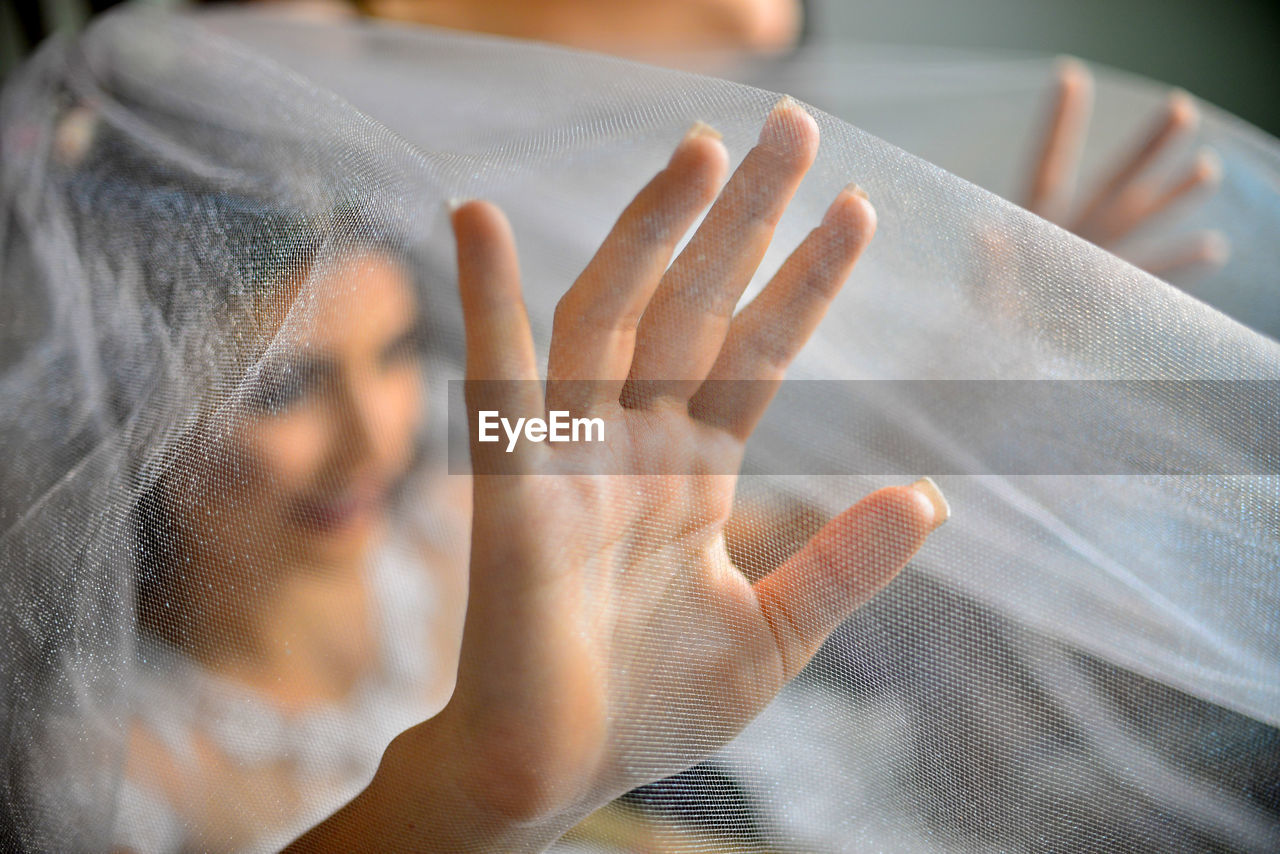 Bride seen through veil while at home