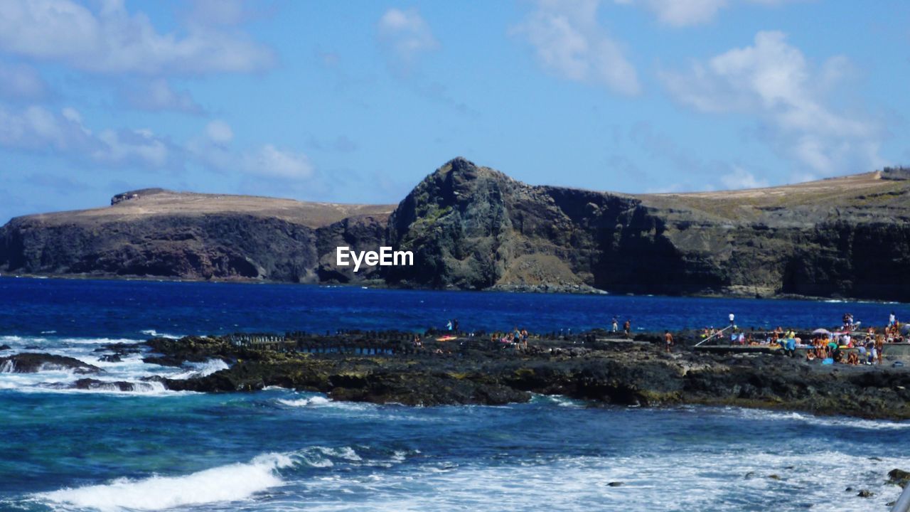 SCENIC VIEW OF SEA WITH MOUNTAINS IN BACKGROUND