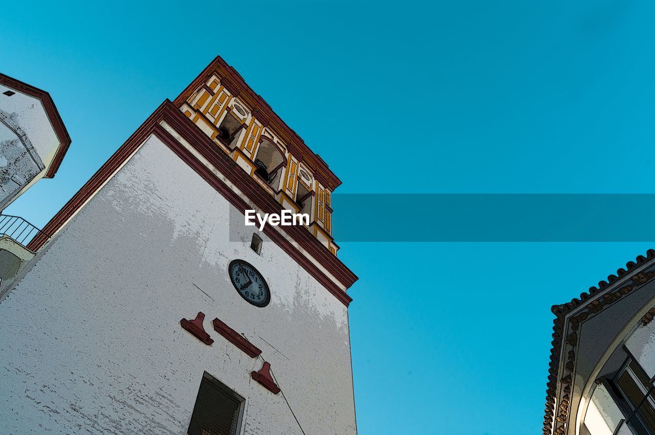 LOW ANGLE VIEW OF CLOCK TOWER AGAINST BLUE SKY