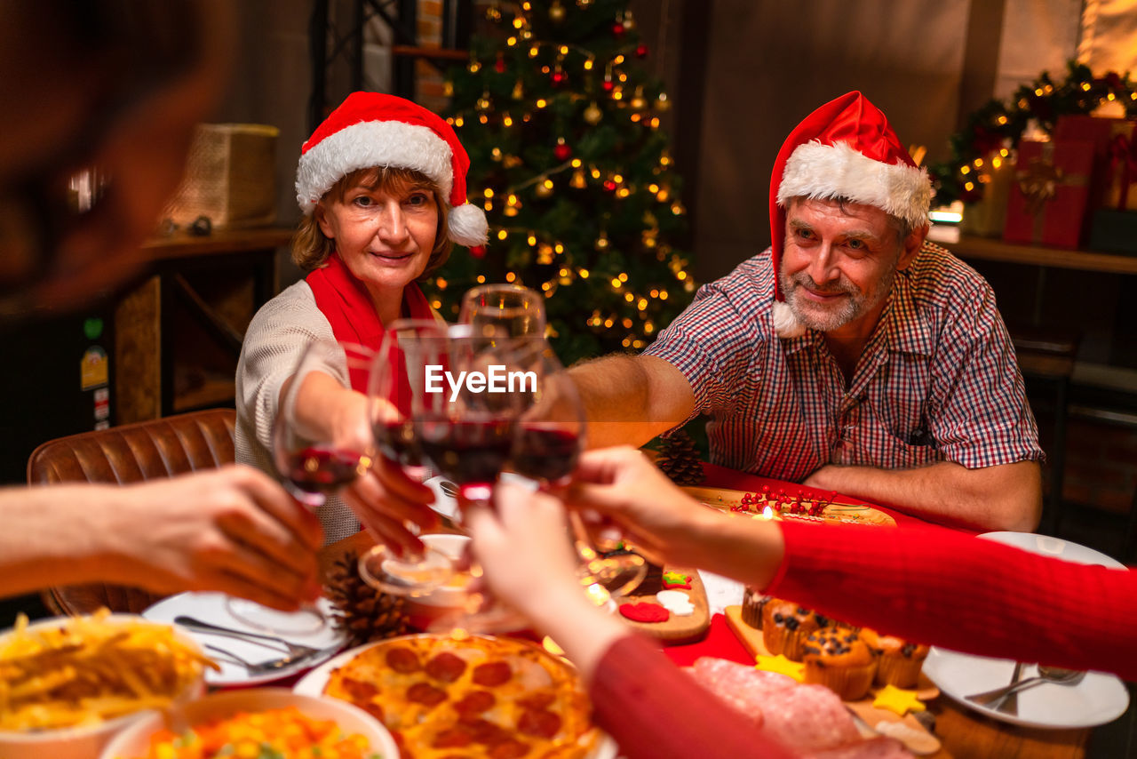 portrait of smiling friends toasting drinks on table