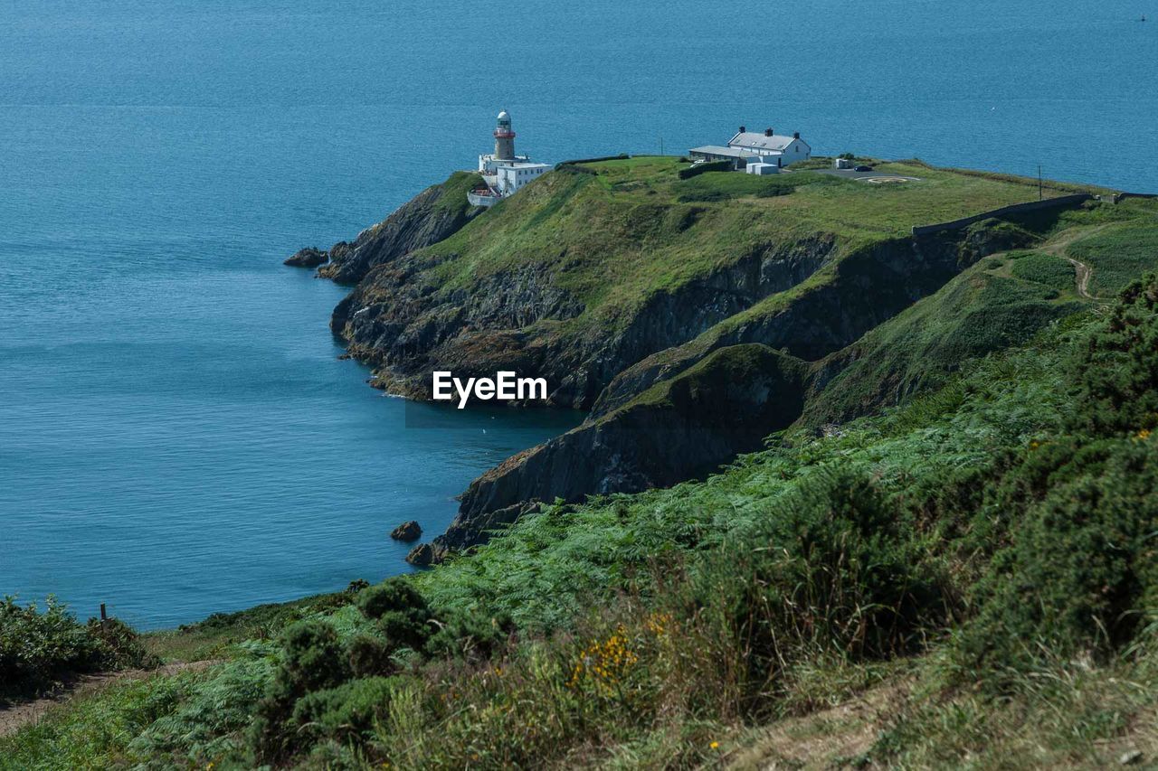 High angle view of cliff by sea against clear sky