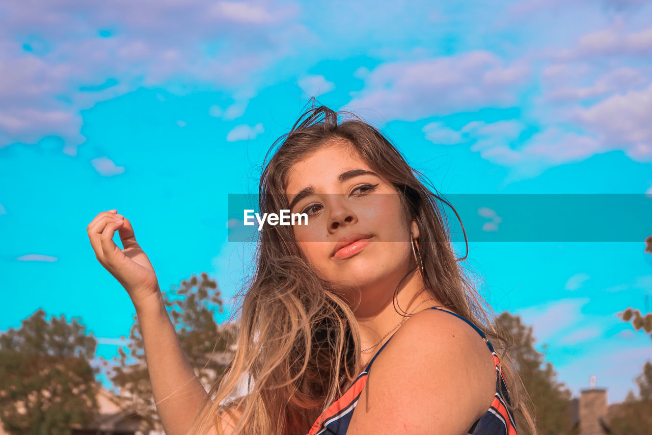 Portrait of beautiful woman smiling against blue water