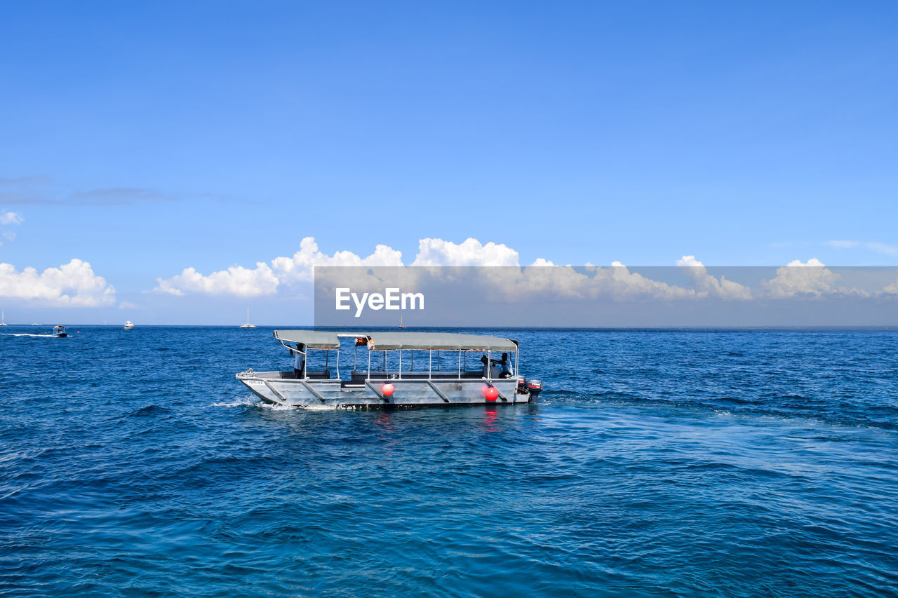 Fishing boat in sea against sky