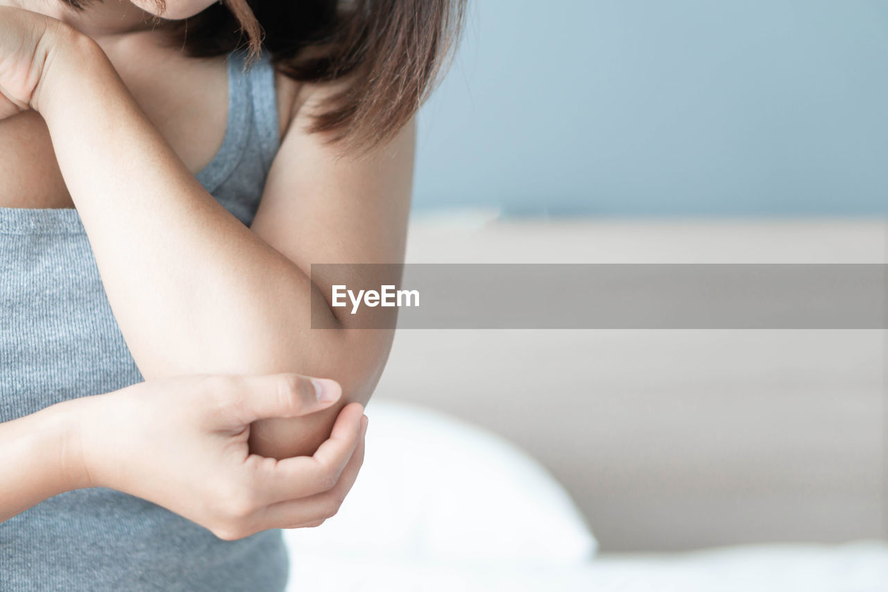 Midsection of woman holding elbow