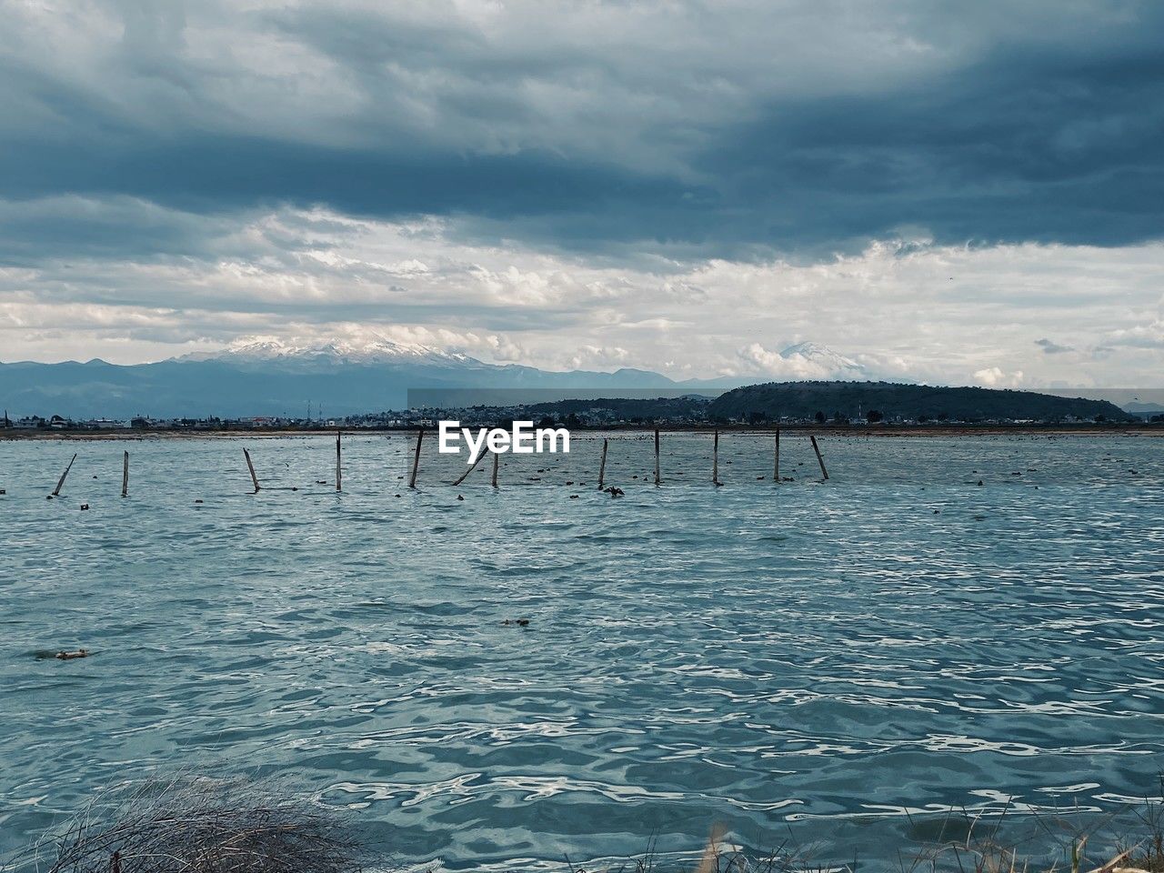 water, sky, sea, shore, horizon, cloud, ocean, nature, scenics - nature, wave, beauty in nature, coast, environment, body of water, bay, reflection, land, architecture, no people, tranquility, mountain, travel destinations, landscape, tranquil scene, travel, outdoors, day, beach, built structure, blue, tourism, pier, seascape, transportation, dusk, non-urban scene, idyllic