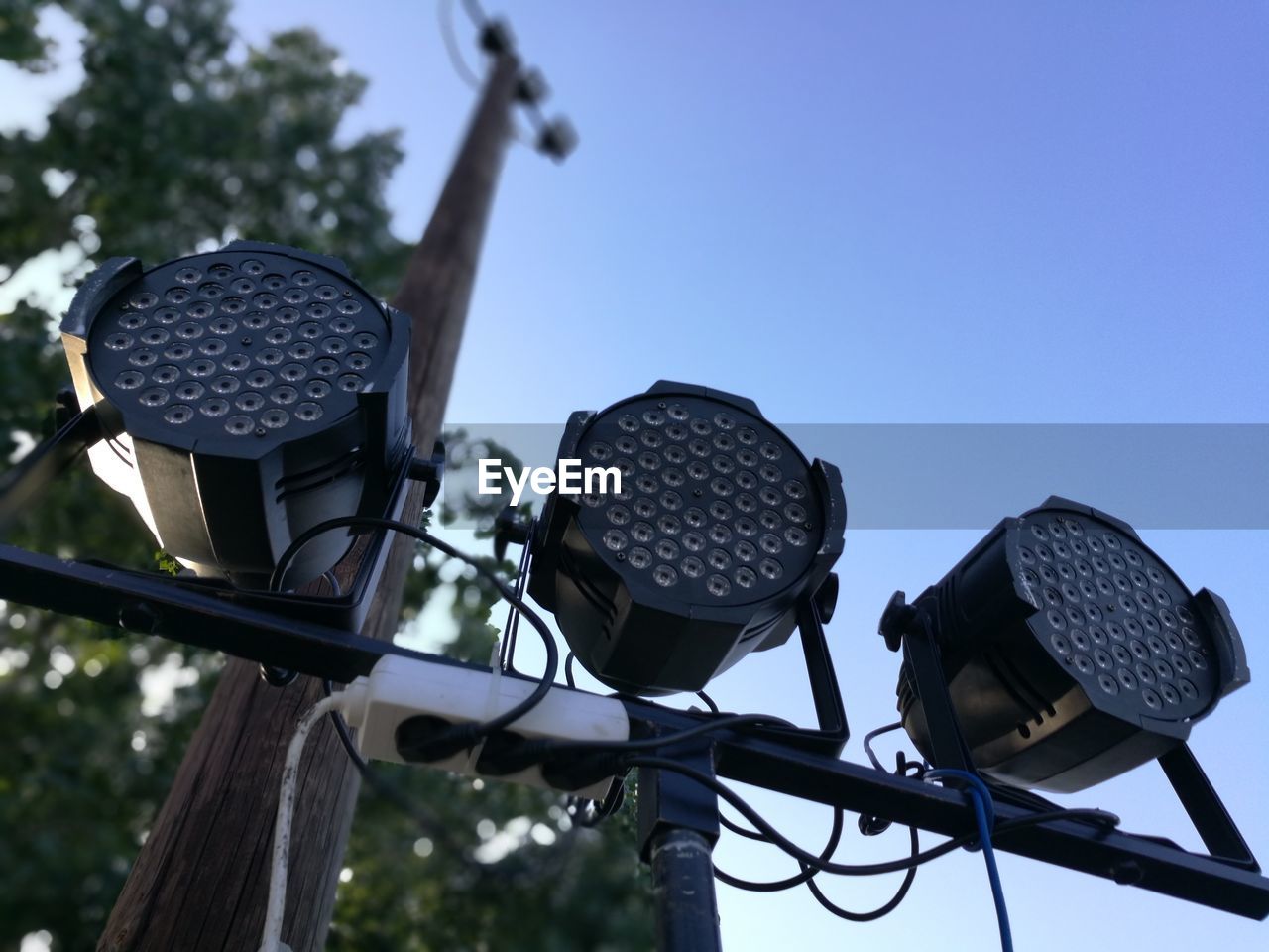 Low angle view of spotlights against clear blue sky
