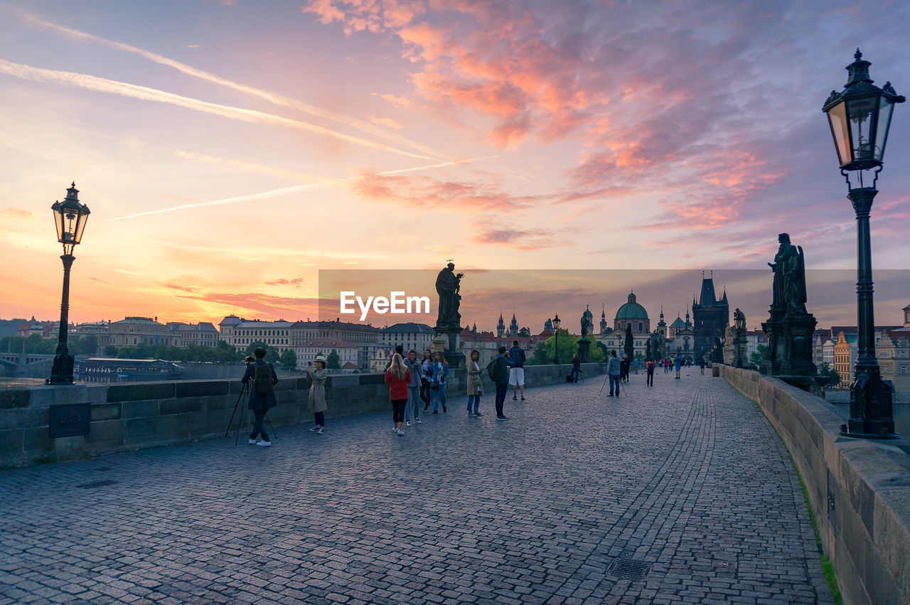 Tourists at sunrise on charles bridge landmark in prague, czech republic