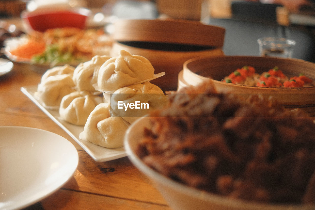 food and drink, food, freshness, dish, asian food, table, healthy eating, meal, indoors, bowl, dinner, wellbeing, chinese food, supper, selective focus, plate, breakfast, cuisine, no people, restaurant, fast food, vegetable, mandu, brunch, meat, still life, serving size, dumpling, close-up