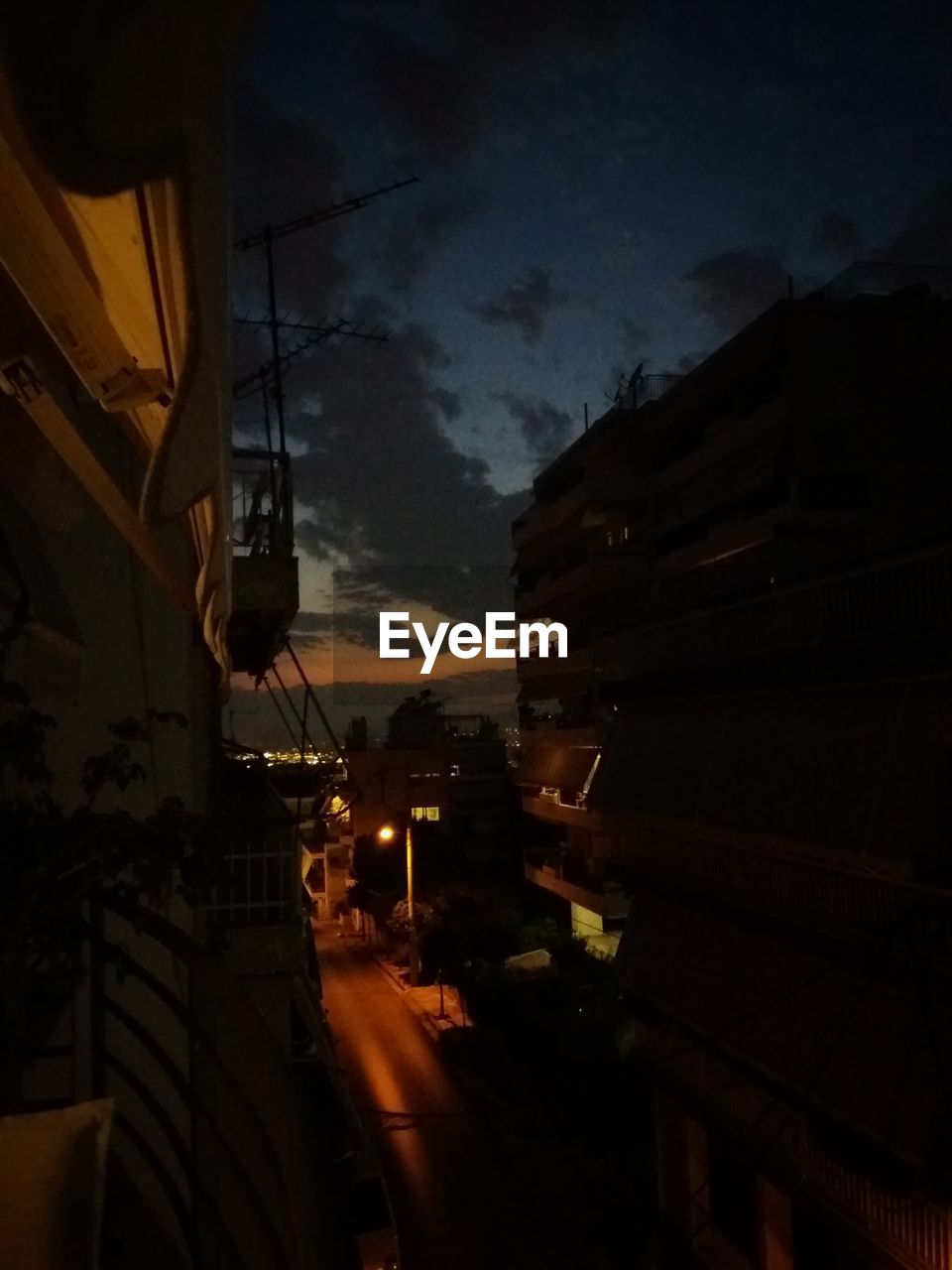 LOW ANGLE VIEW OF ILLUMINATED STREET LIGHTS AGAINST SKY AT NIGHT