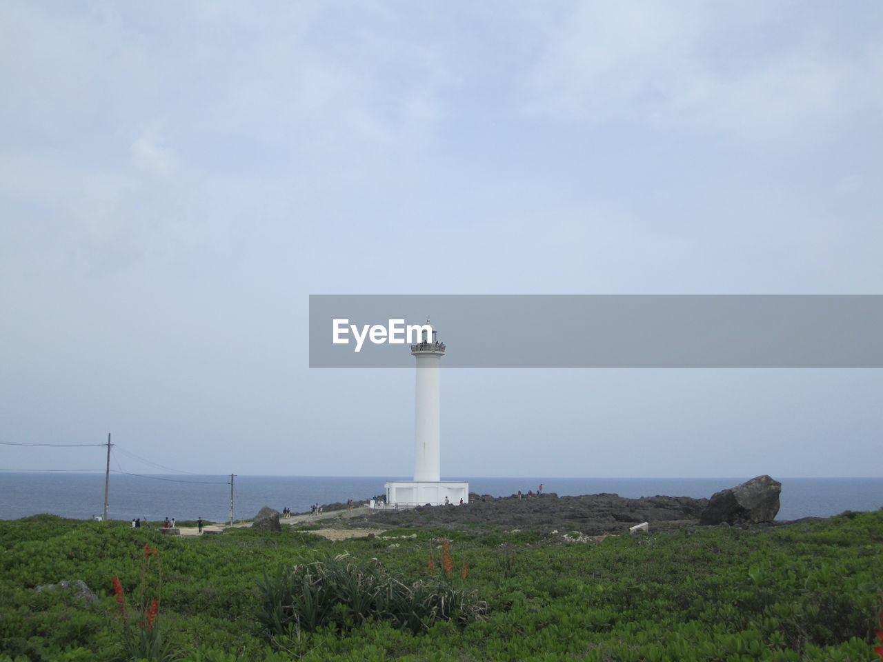 Lighthouse by sea against sky