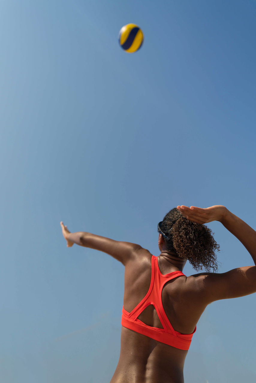 Woman with afro hair playing beach volleyball