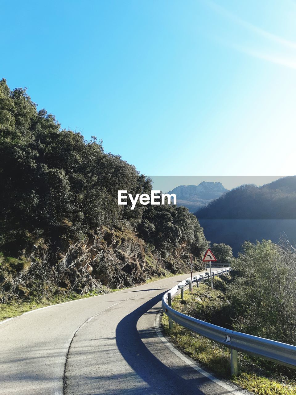 ROAD BY MOUNTAIN AGAINST BLUE SKY