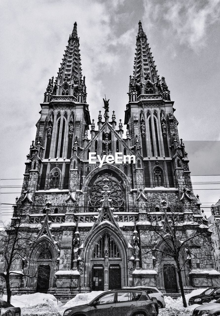 Low angle view of cathedral against cloudy sky during winter