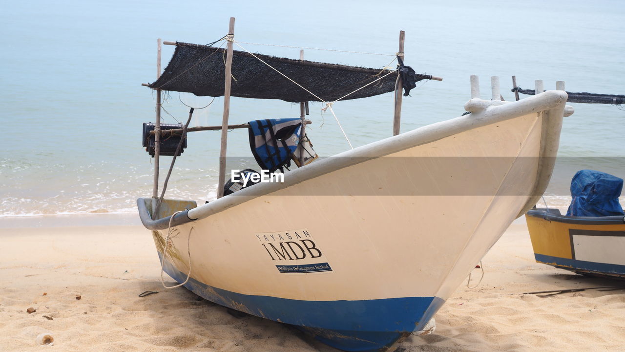 BOAT MOORED ON BEACH