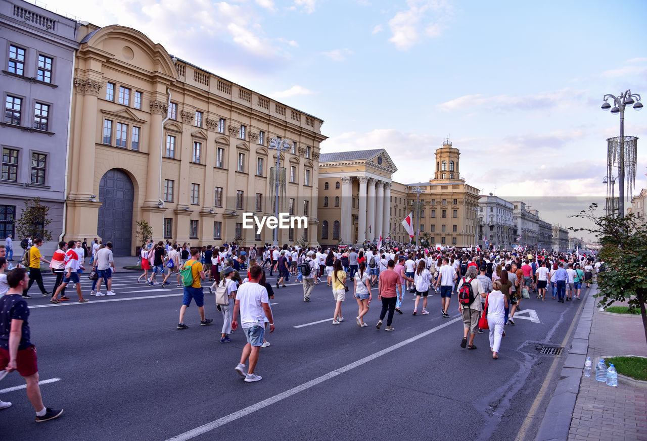 GROUP OF PEOPLE ON STREET AGAINST BUILDINGS