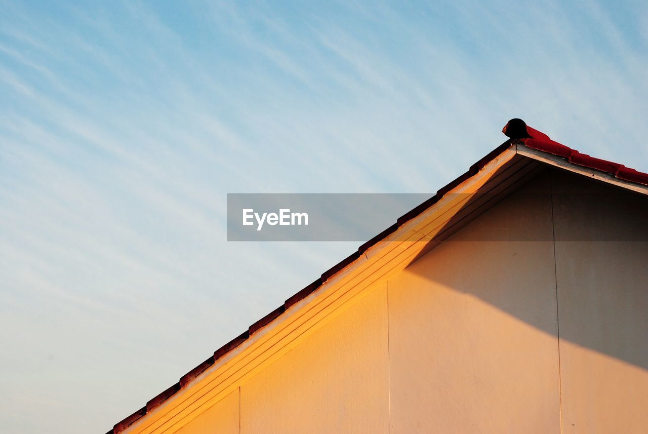 Exterior of building with triangular roof against cloudy sky