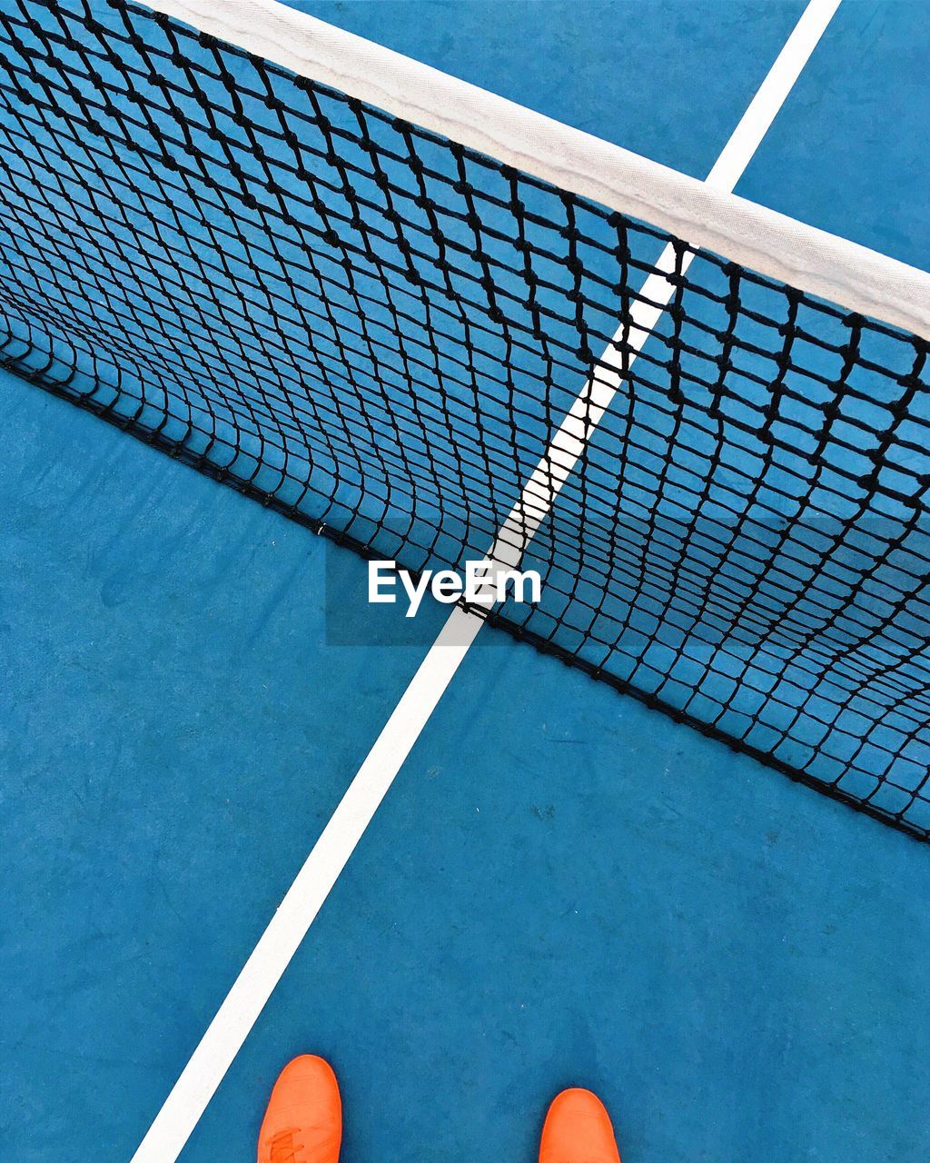 Low section of person standing on tennis court