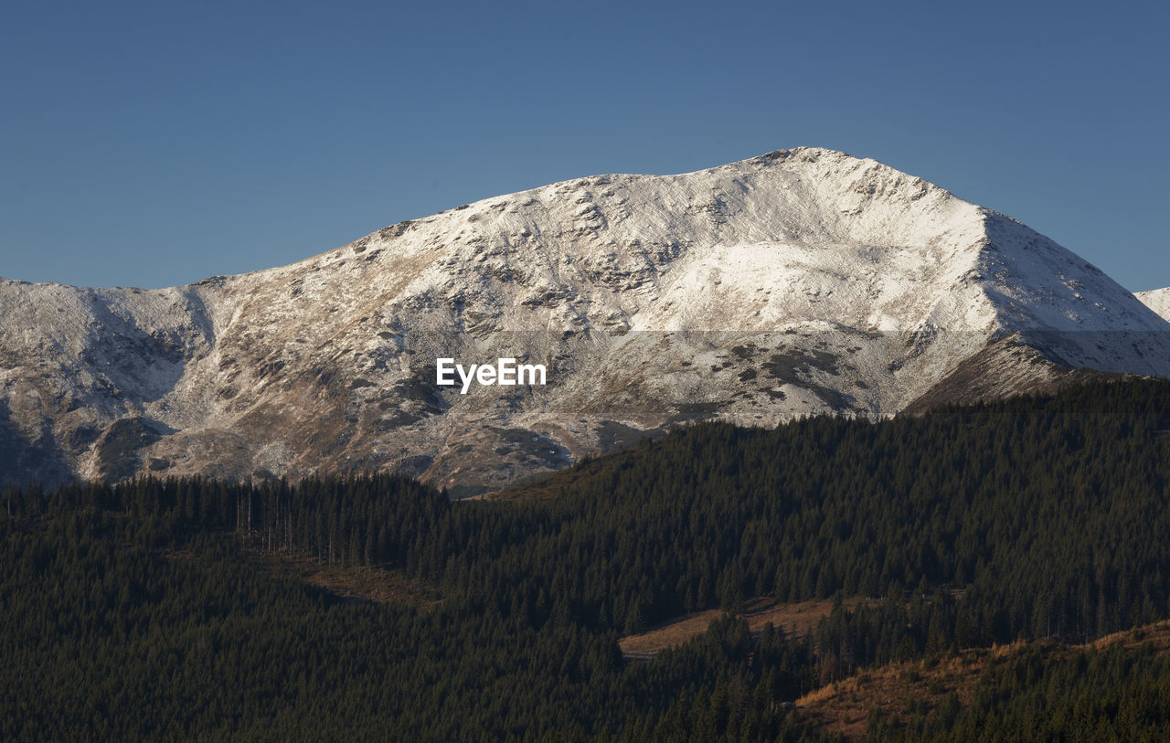 Scenic view of snowcapped mountains against clear sky