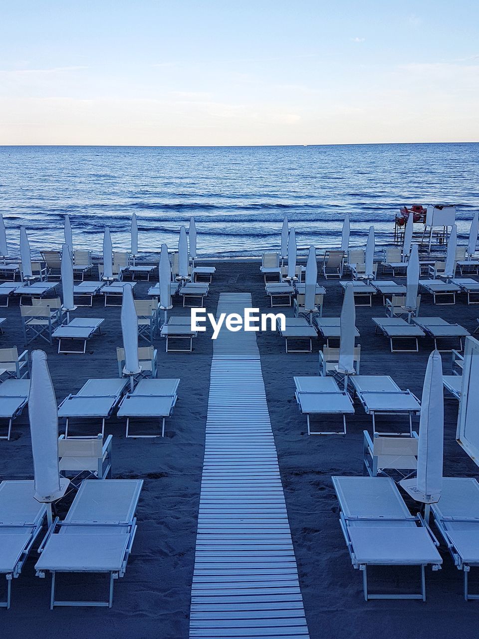 CHAIRS ON BEACH AGAINST SKY