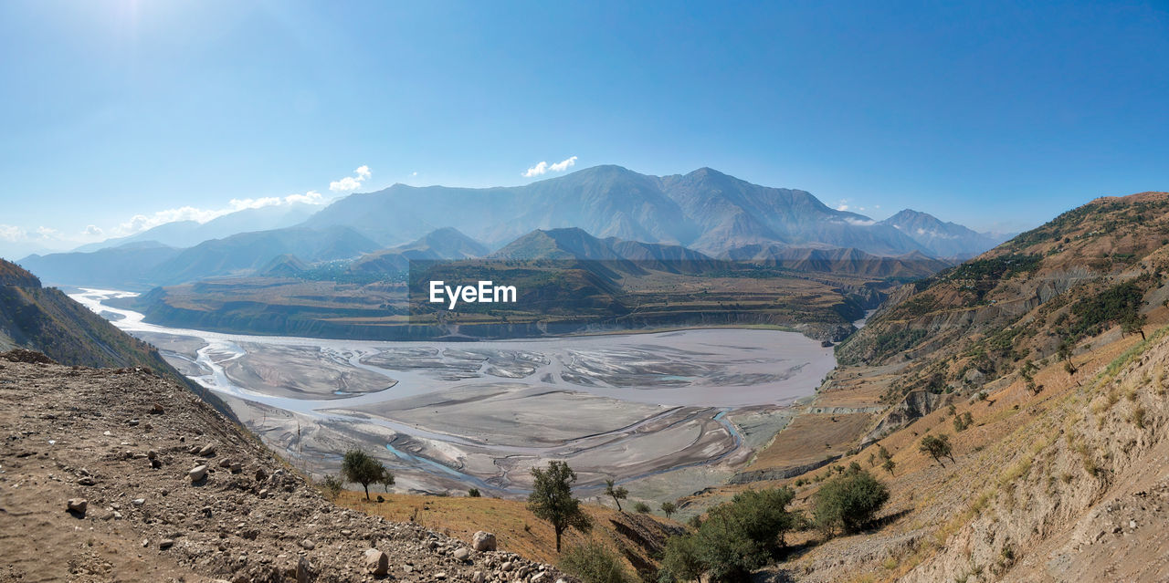 Panoramic view of landscape and mountains against blue sky