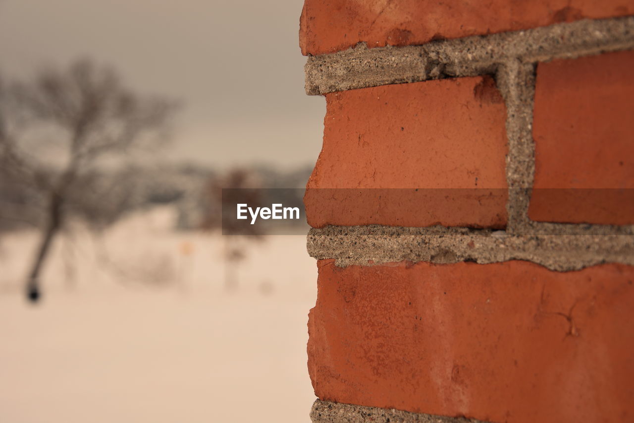 CLOSE-UP OF RUSTY METAL AGAINST WALL AGAINST SKY