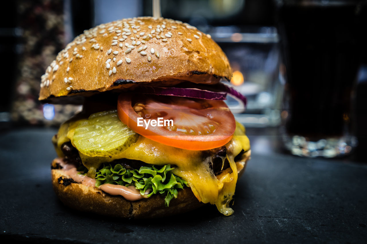 food and drink, food, sandwich, fast food, hamburger, unhealthy eating, bread, vegetable, freshness, veggie burger, meal, lettuce, bun, dish, take out food, cheese, meat, indoors, tomato, fruit, close-up, seed, yellow, no people, sesame, business