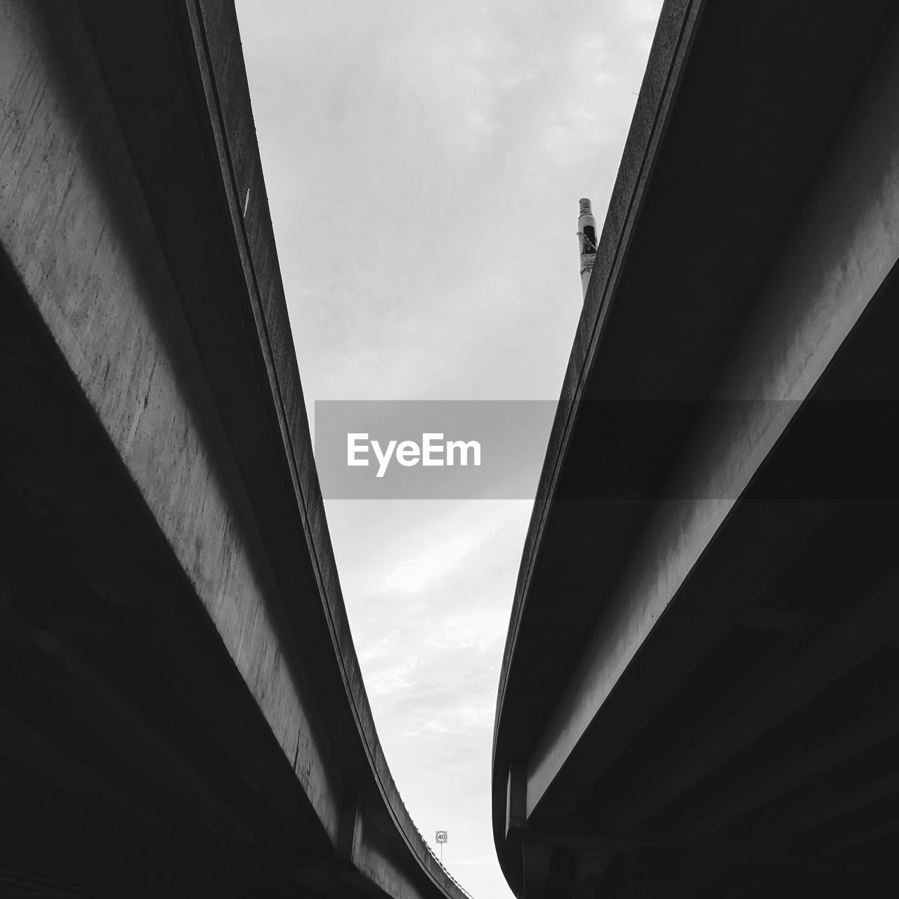 Low angle view of bridge over buildings against sky