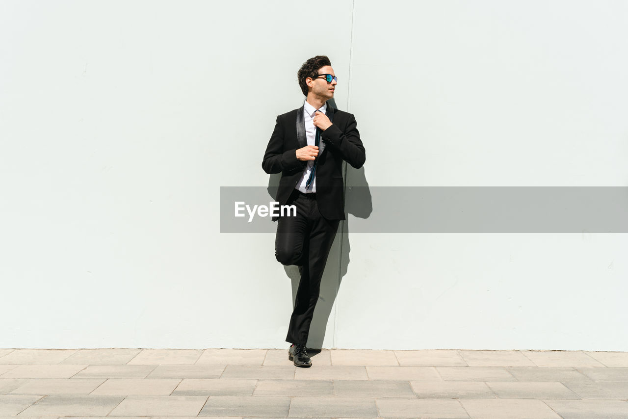 full length of young man standing against wall