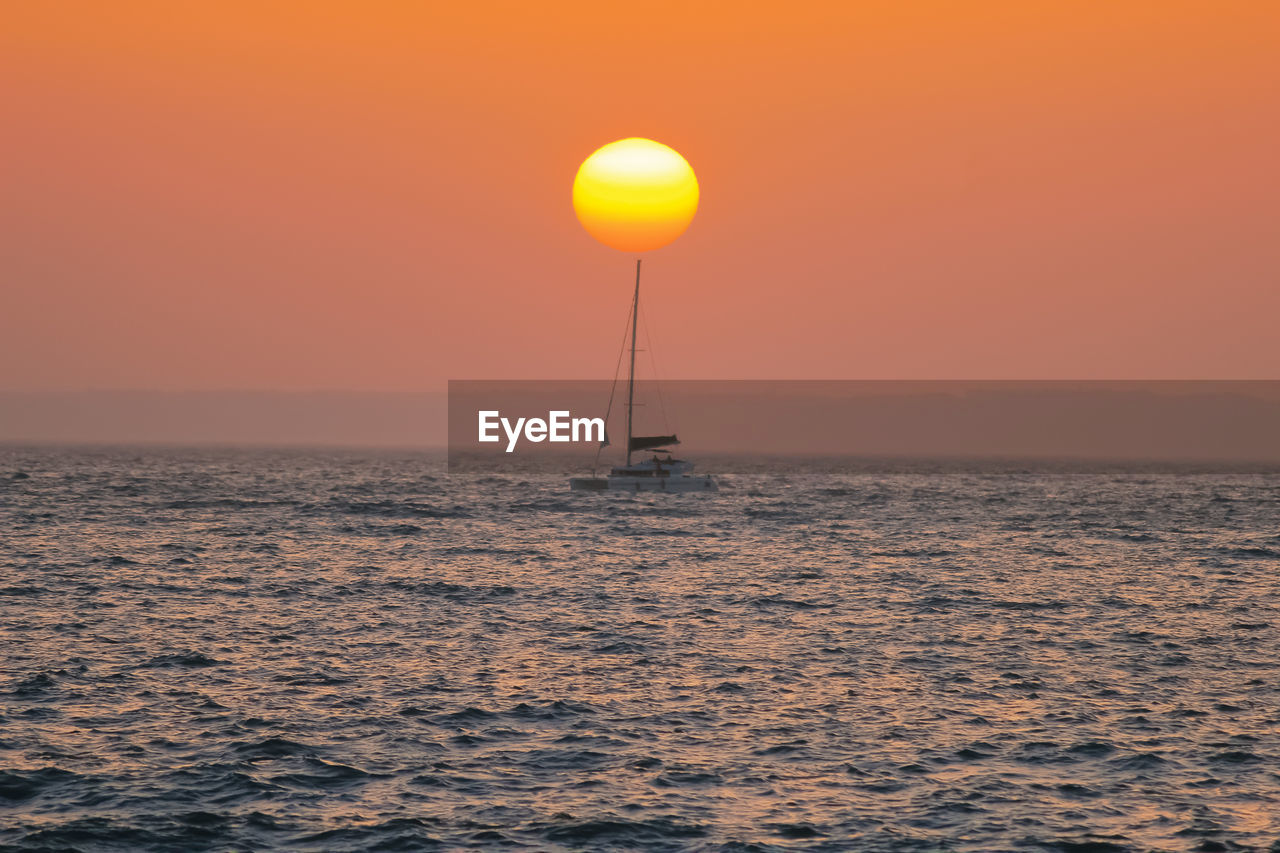 SCENIC VIEW OF SEA AGAINST SKY AT SUNSET