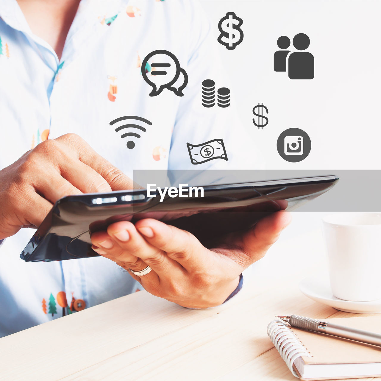 Digital composite image of businessman using digital tablet with various icons