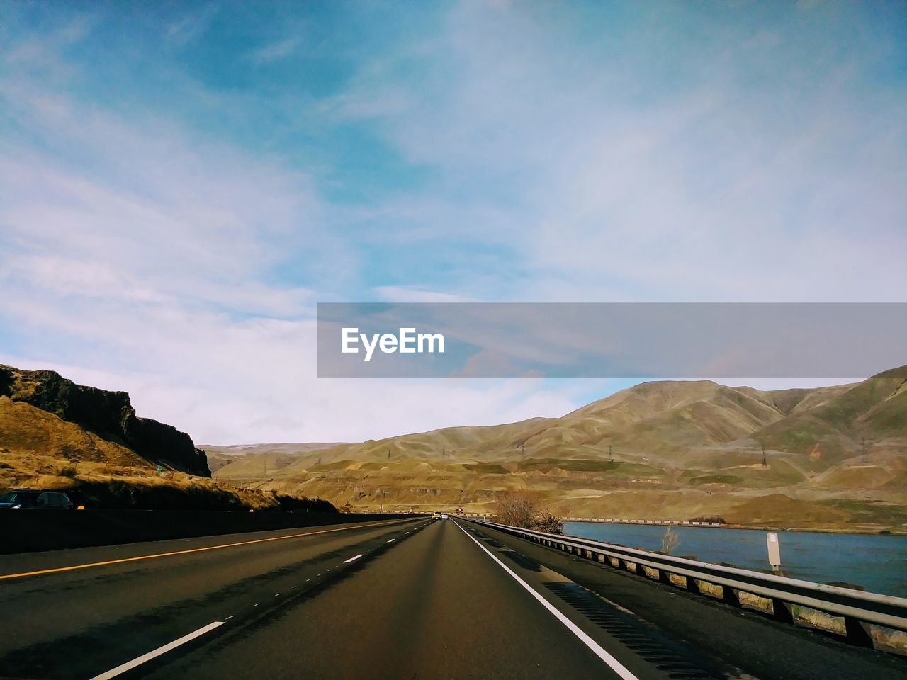 EMPTY ROAD BY MOUNTAIN AGAINST SKY