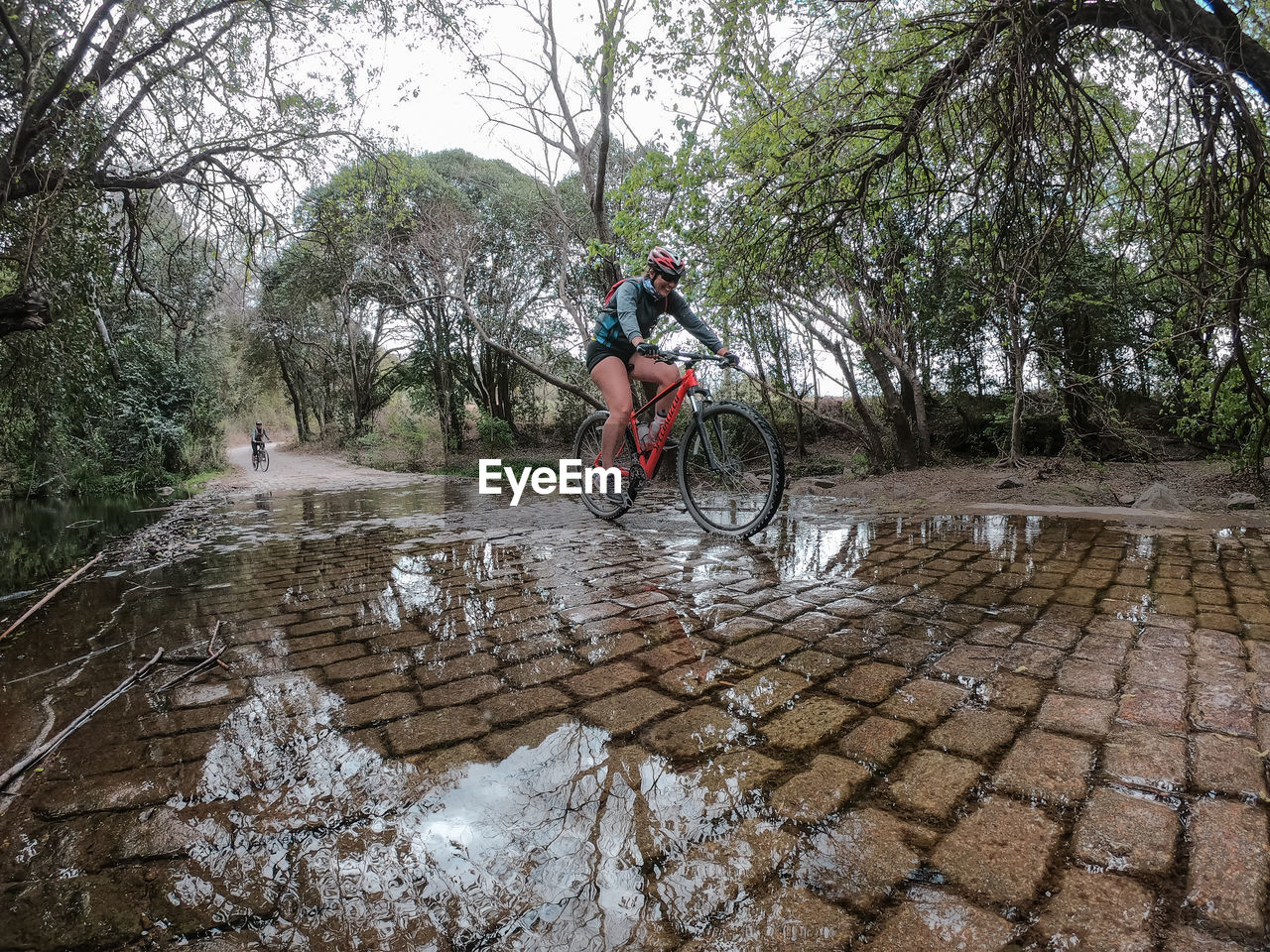 MAN RIDING BICYCLE ON RAINY SEASON