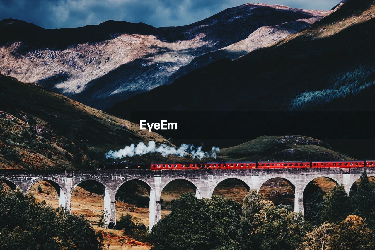 Arch bridge against cloudy sky