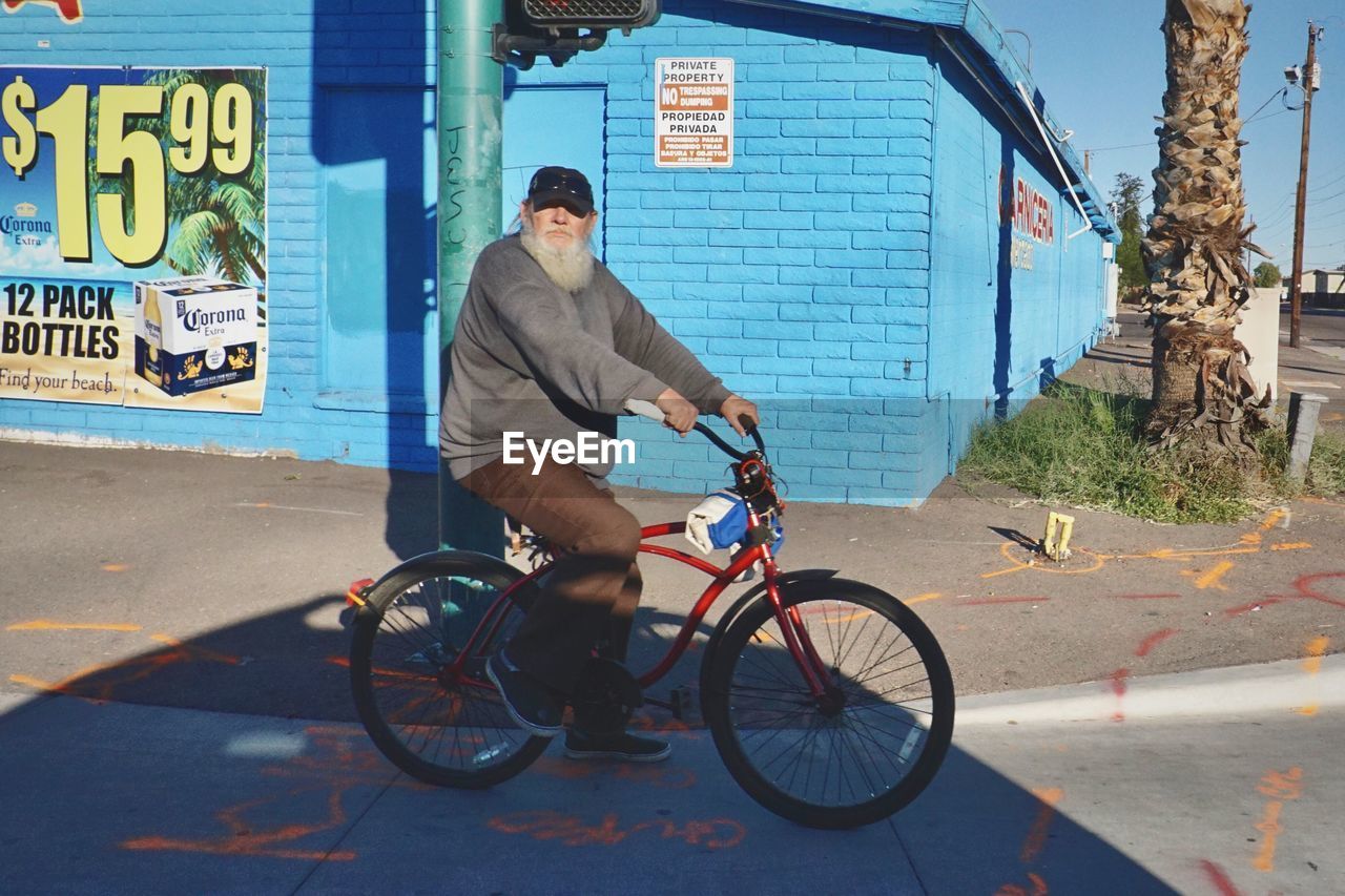 YOUNG MAN RIDING BICYCLE ON CITY