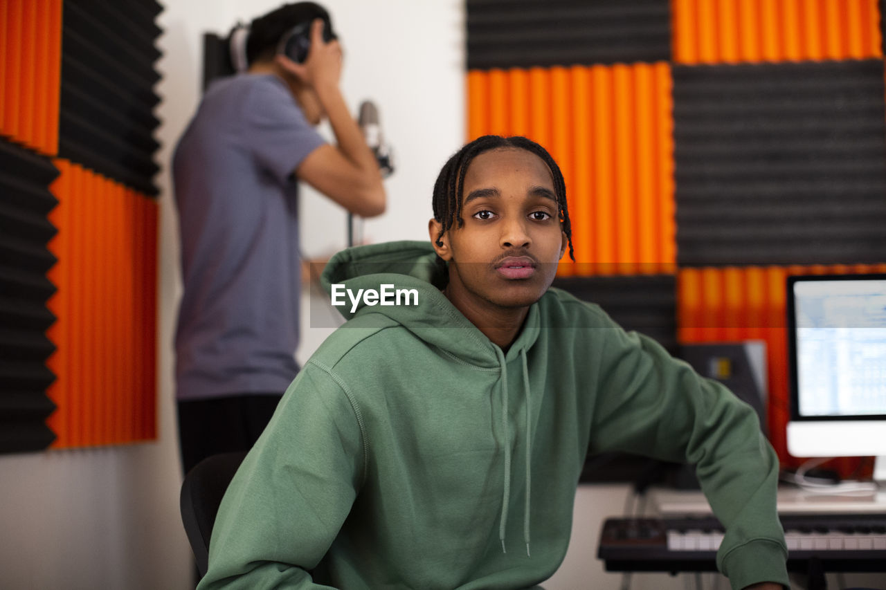 Teenage boy with dreads sitting in recording studio