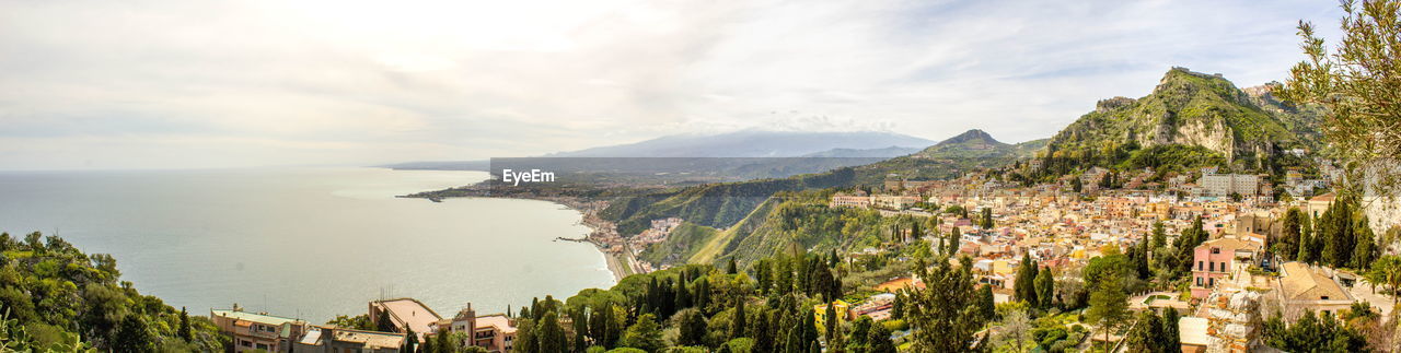 PANORAMIC VIEW OF BUILDINGS AND SEA AGAINST SKY