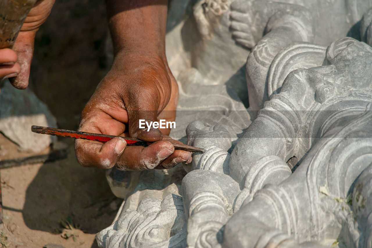 Cropped hands of man working on sculpture