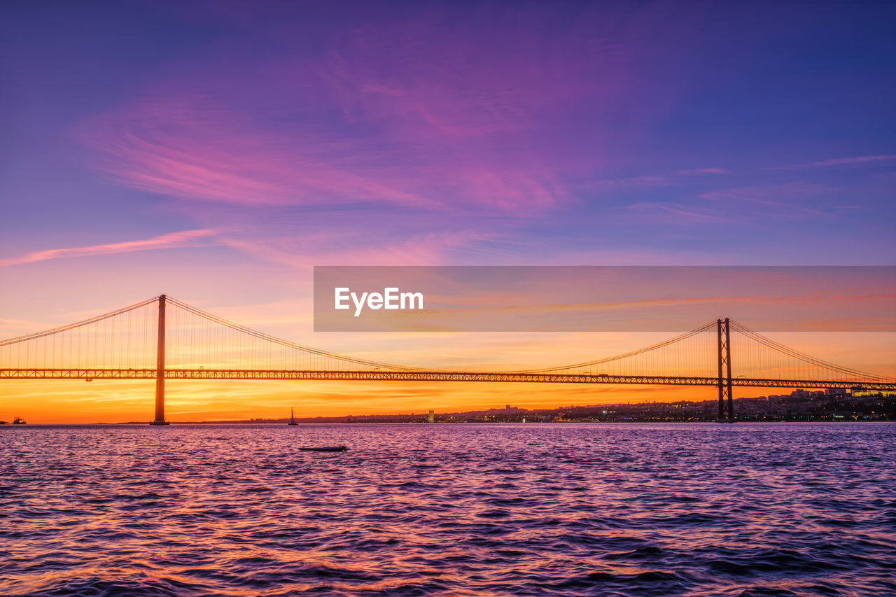 View of 25 de abril bridge over tagus river on sunset. lisbon, portugal