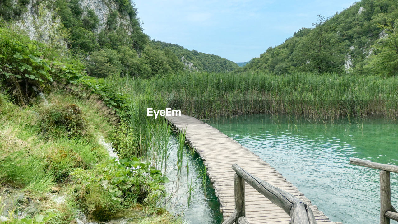 Scenic view of plitvice lake by trees against sky