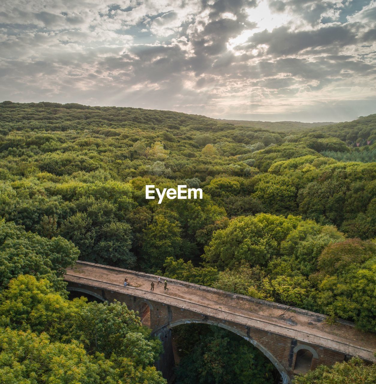 Arch bridge over landscape against sky