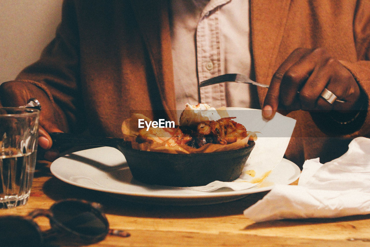 Midsection of man having meal at table