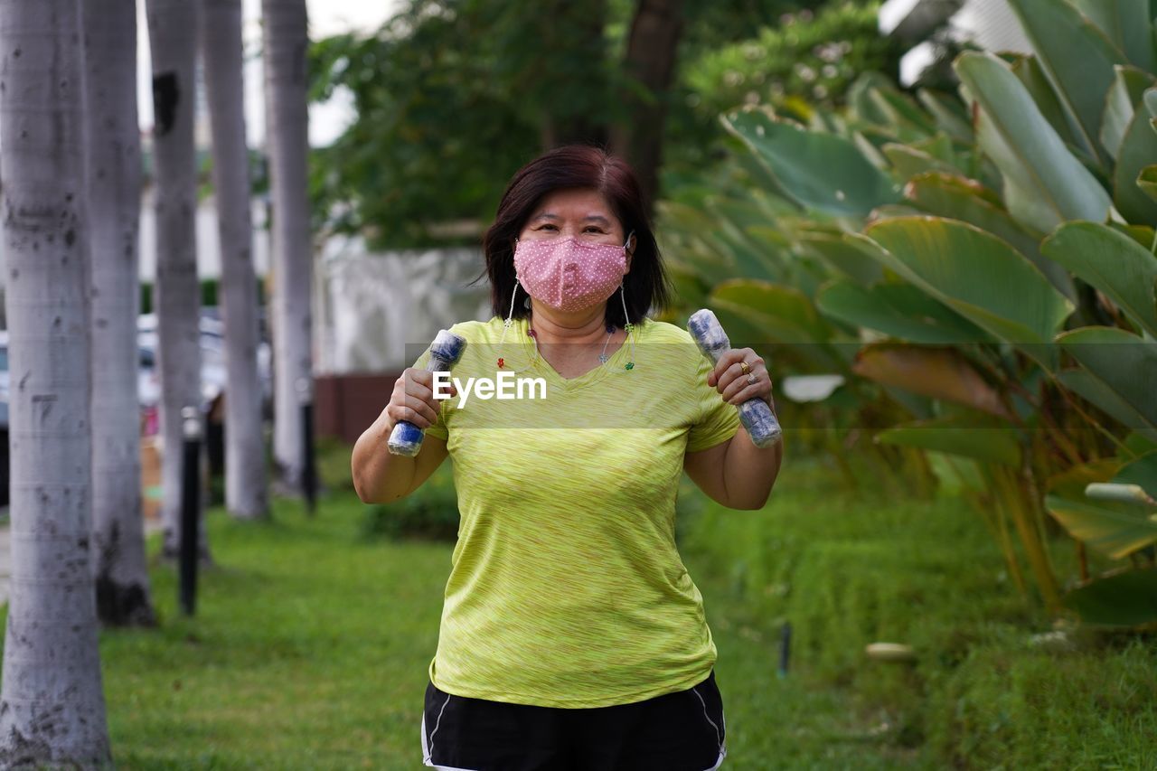 Asian women wearing masks to prevent coronavirus during exercise at park.